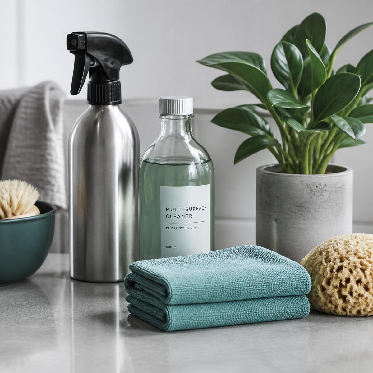 Cleaning supplies in a wicker basket on a warm, freshly cleaned kitchen counter